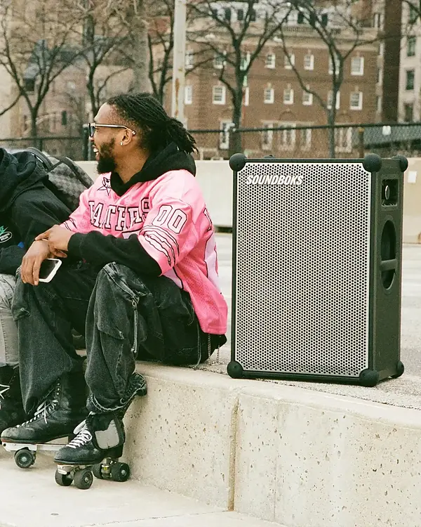 Enceinte SOUNDBOKS 4 posée en ville près de deux personnes