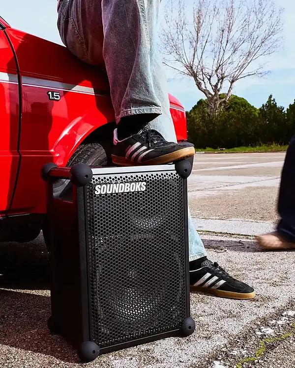 Enceinte SOUNDBOKS Mix posée au pied d’une voiture